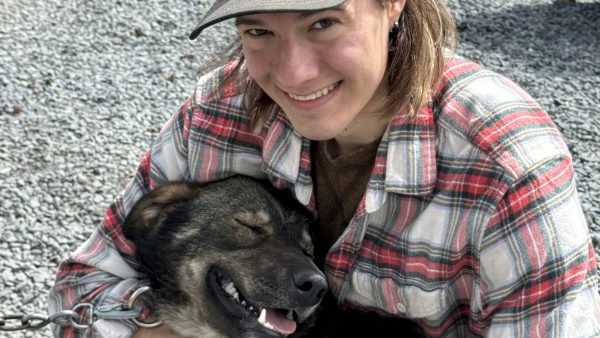 Matt Riese snuggles a Turning Heads Kennel dog on our summer dog sledding adventure